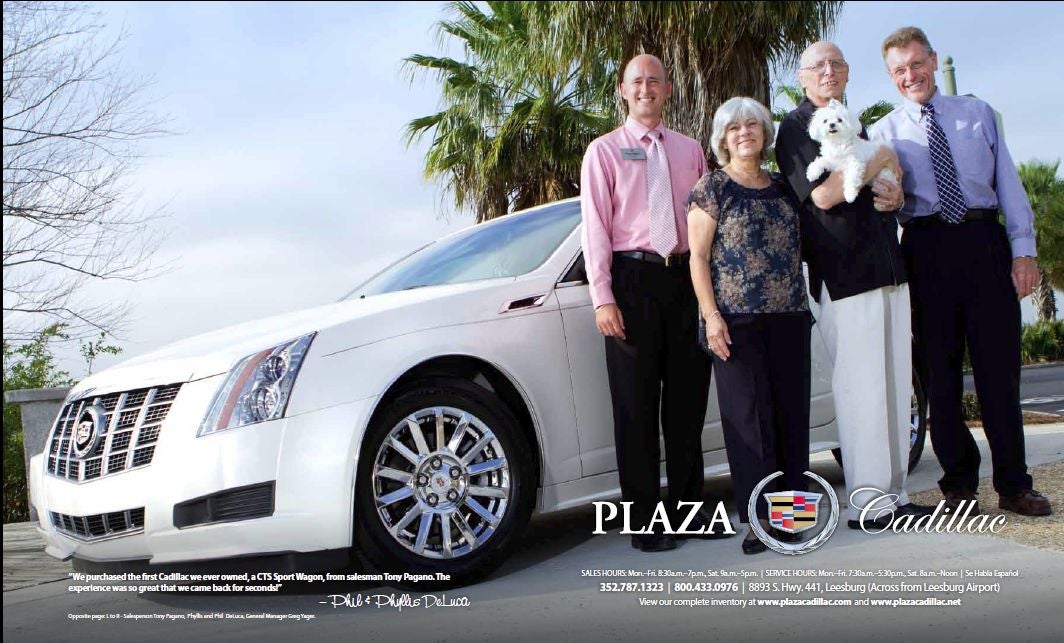 4 adults and a dog next to a white Cadillac