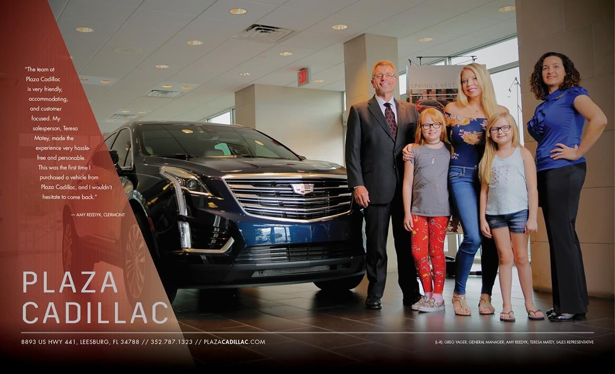 3 adults and 2 children next to a blue Cadillac
