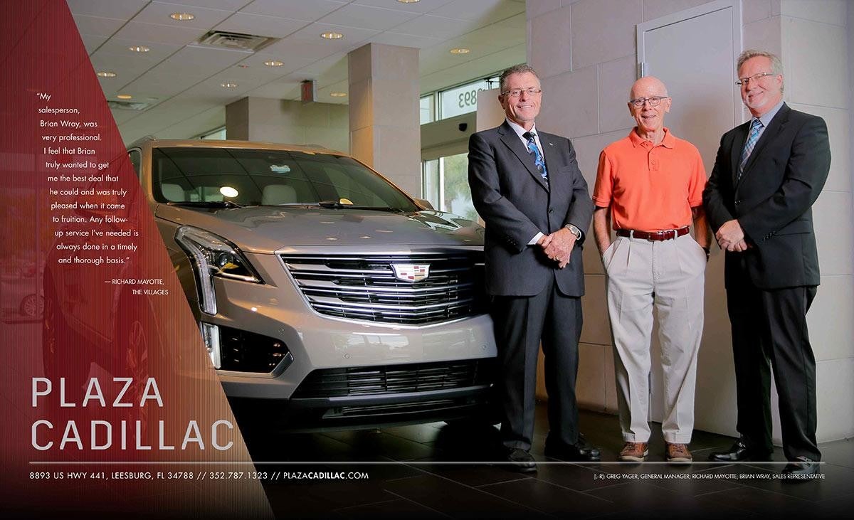 3 men next to a grey Cadillac